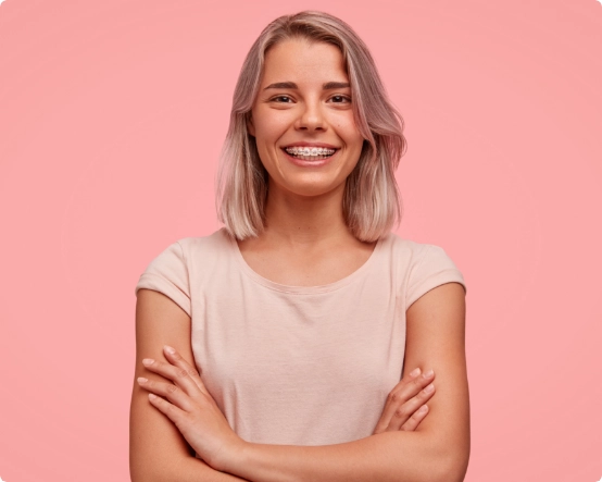 Lächelnde blonde Frau mit Zahnspange auf einem rosafarbenen Hintergrund
